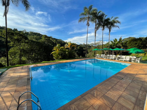 piscina da pousada recanto do chalé com vista para mata