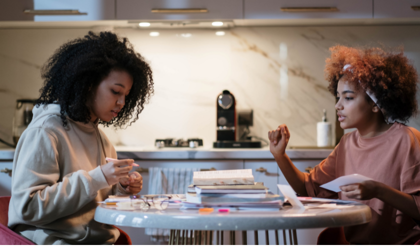 two sisters studying test materials in kitchen