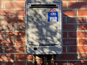 Vulcan DuoMax gas hot water unit mounted on a red brick wall, representing expert hot water system installation.