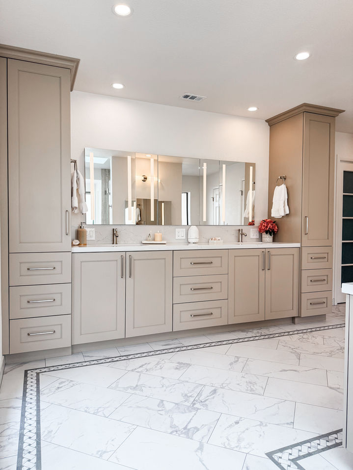 Modern bathroom with double sink vanity, mirrors, cabinets, and marble flooring.