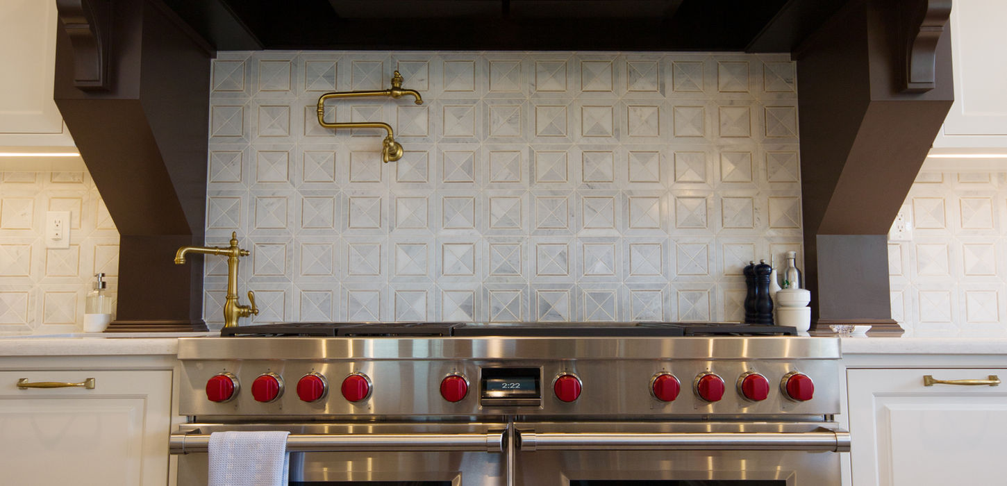 Luxury cooking area with custom range hood and built-in cabinetry