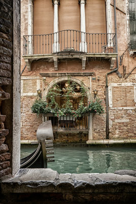 A romantic view of Venice with a gondola in a typical canal, ideal for an elopement or luxury wedding in Italy.