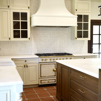 Custom cream kitchen cabinetry with La Cornue range and walnut island
