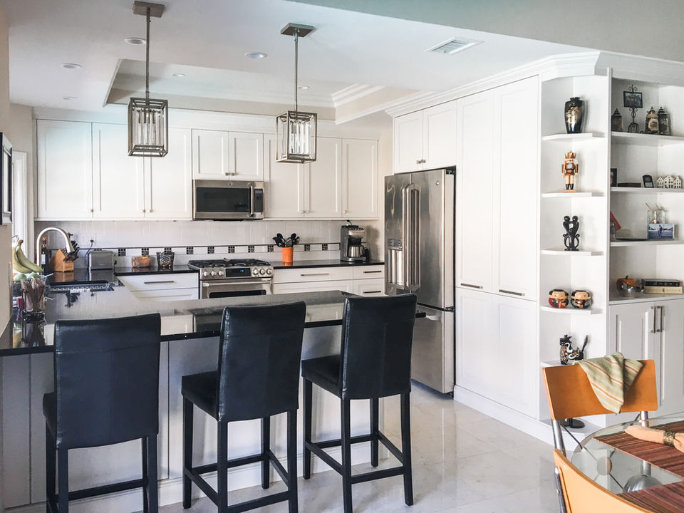 Modern white kitchen with black countertop and bar stools Legourmet Kitchen.