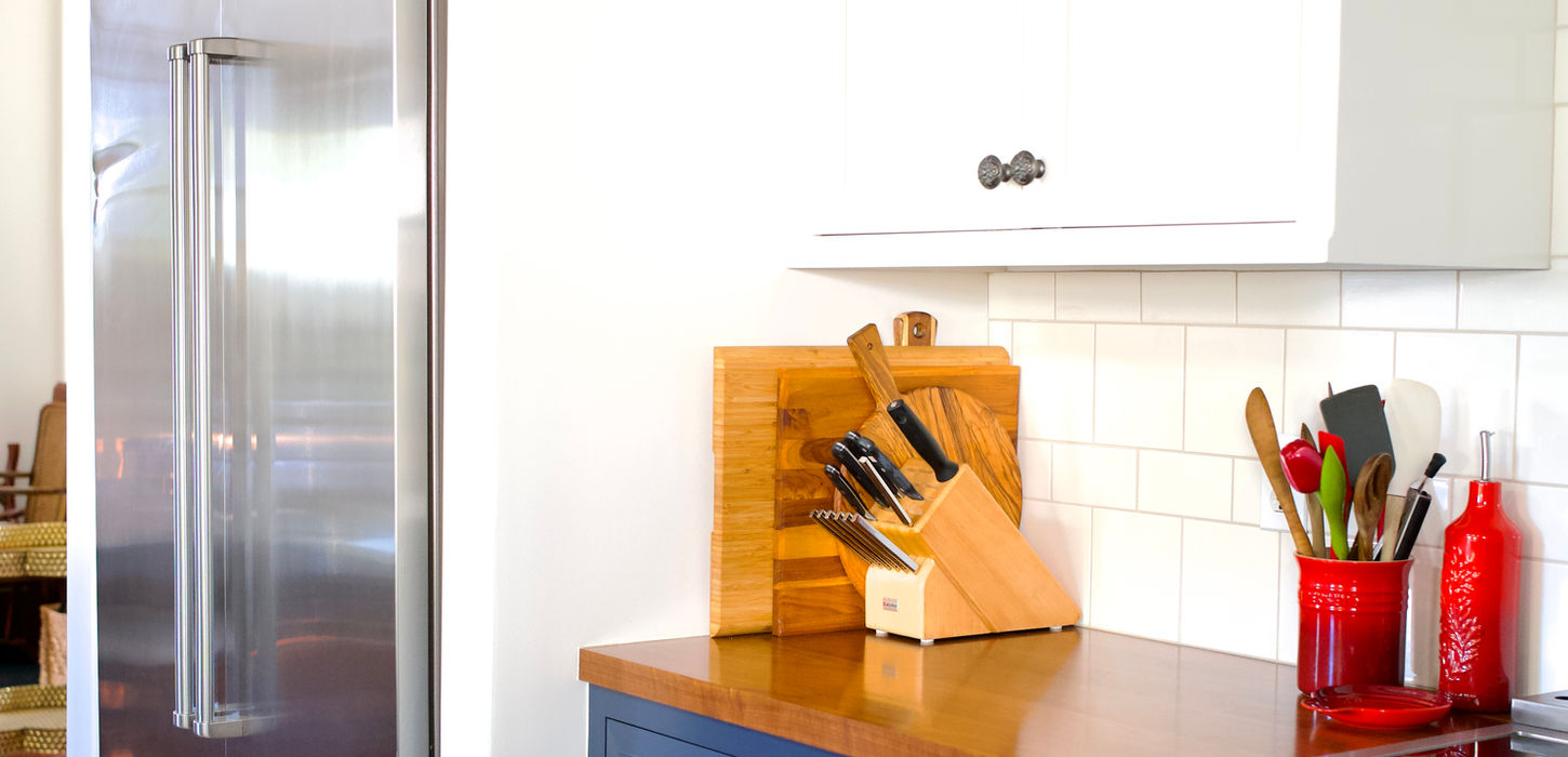 Blue kitchen cabinets with custom storage and countertop workspace