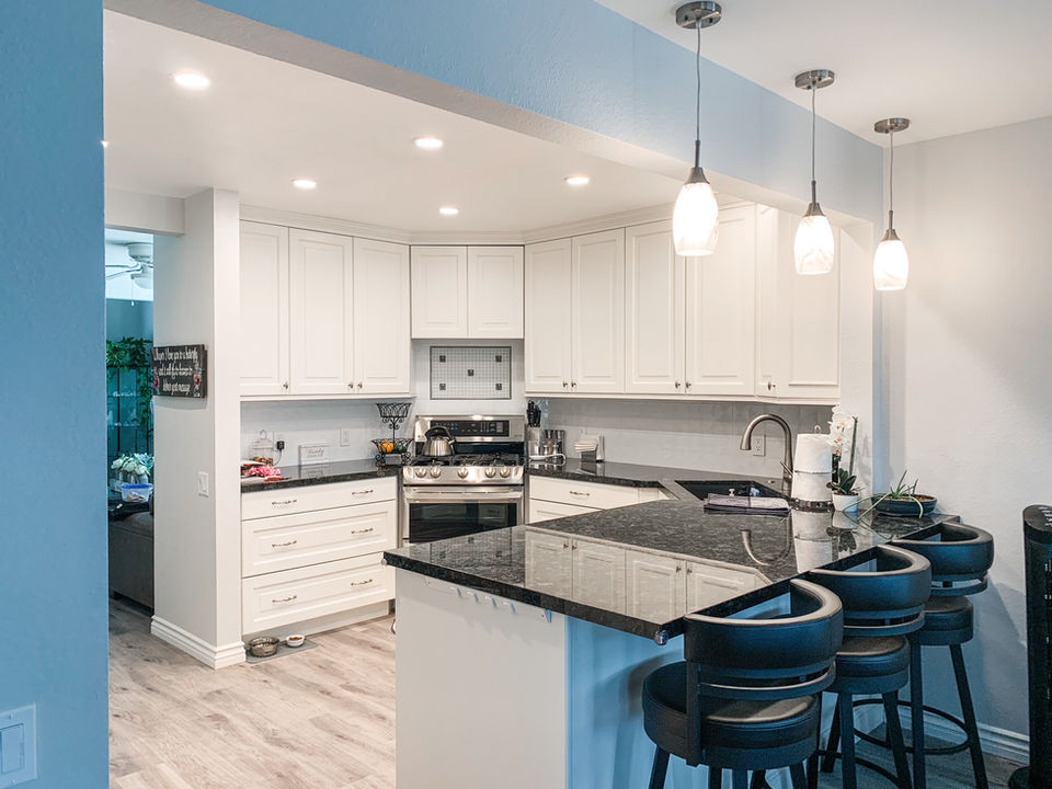Modern white kitchen with black countertops and pendant lights, Legourmet Kitchen.