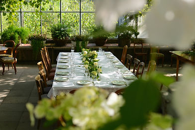 Elegant wedding dinner tablescape inside a typical Dutch greenhouse venue, perfectly capturing the blend of historic warmth and modern botanical design.