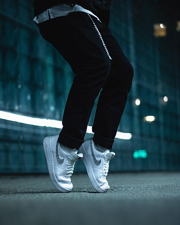 A pair of legs wearing leggings with Nike trainers on two feet standing on tip-toe.