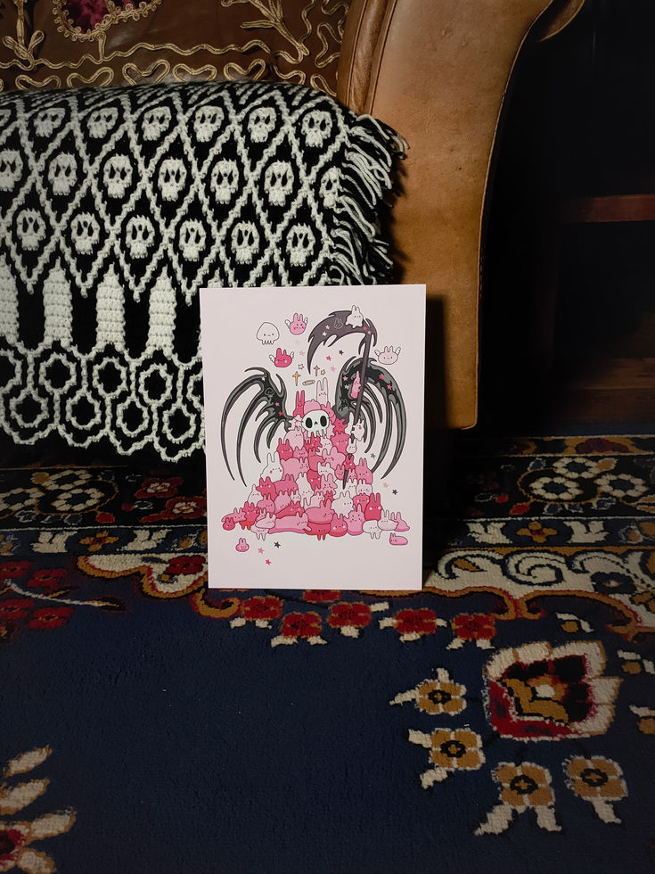 Full view of pink background print with mountain of pastel goth bunnies, a skull on top, skeletal wings and dark scythe