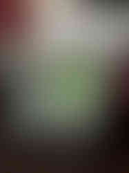 close up of mounted enamel pin badge of shrunken head illustrations. Blue, green and gold colouring.