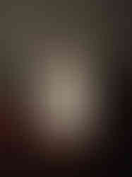 black frame, old book page, frayed denim patch, white embroidered ghost with tan paper bag on head with "human" written on it