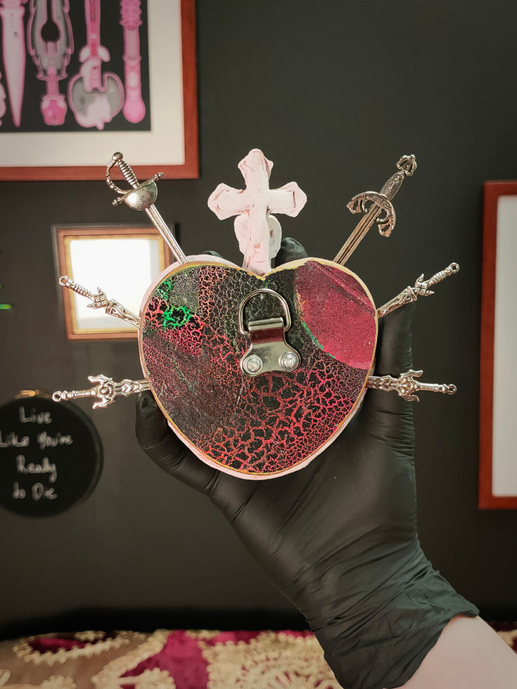 back view of white crackle glazed mini sacred heart sculpture. Rustic and colourful flat surface with metal hook
