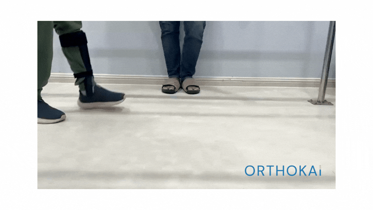 People’s lower legs and shoes in a bright indoor space; ORTHOKAi logo at bottom right.