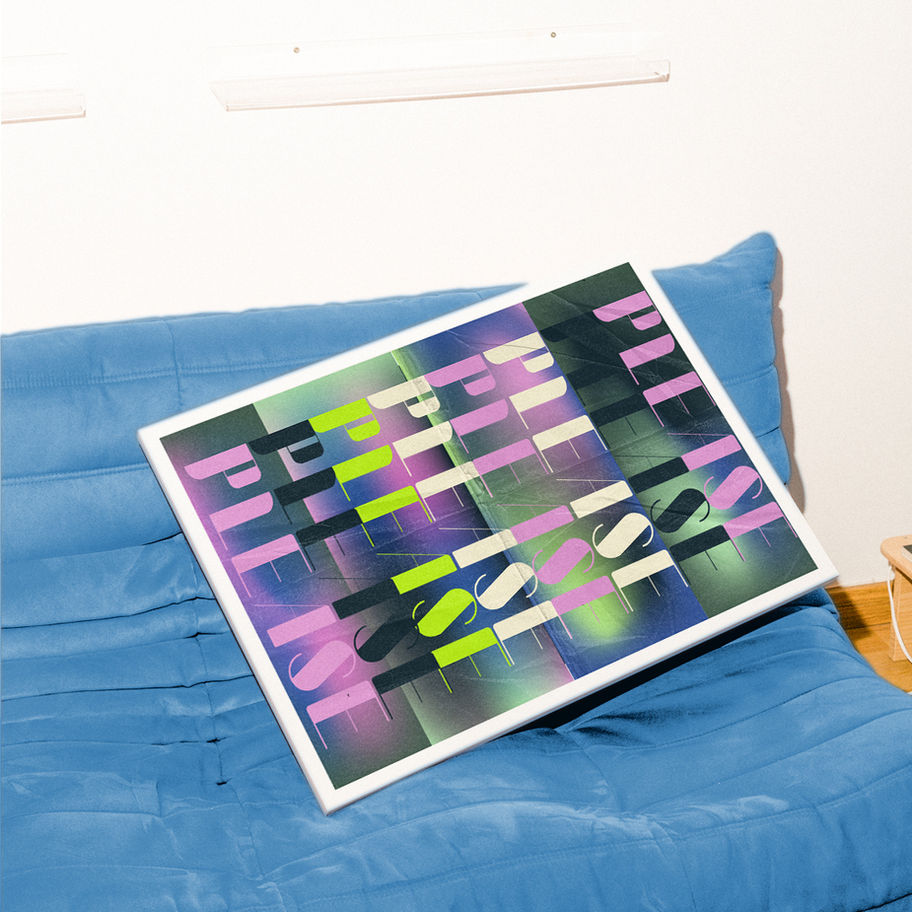 Abstract art print reading “REWORK” on a blue couch, white frame.