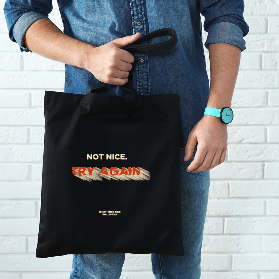 Man holding black tote bag that says "NOT NICE. TRY AGAIN."