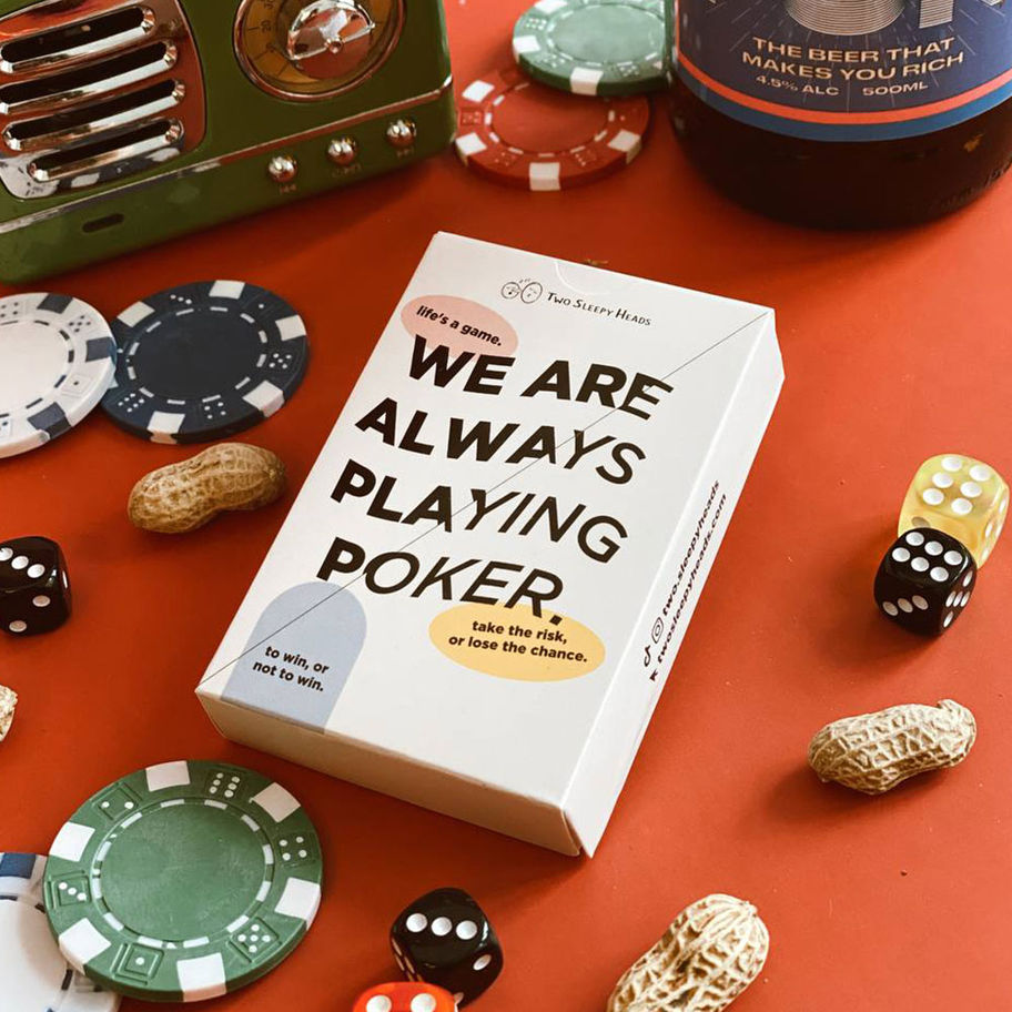 White poker card box with text, dice, chips, peanuts and beer bottle on red