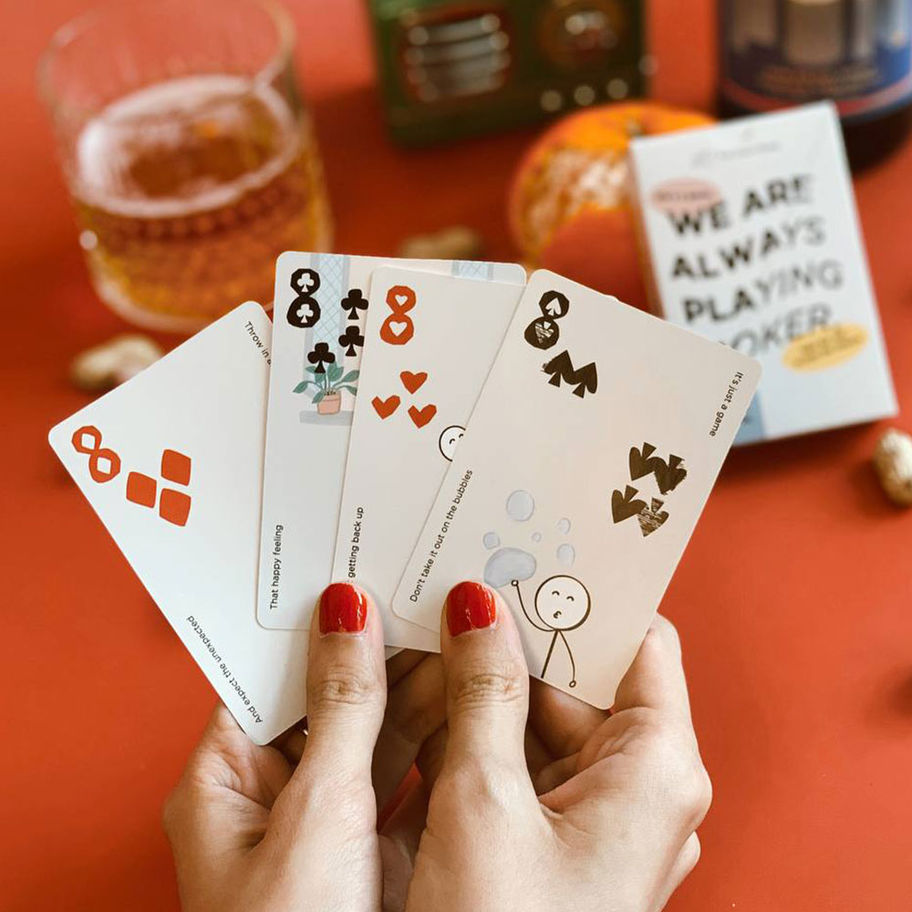 Woman's hands holding playing cards with text,