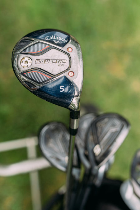 drei Golfschläger in Nahaufnahme mit grünem Rasen im Hintergrund