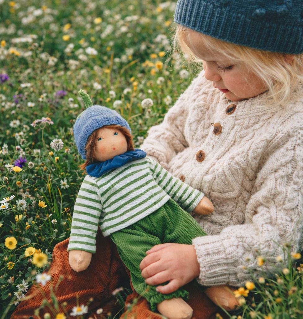 A child holding the Nanchen Natur Waldorf Doll – Flower Child MO