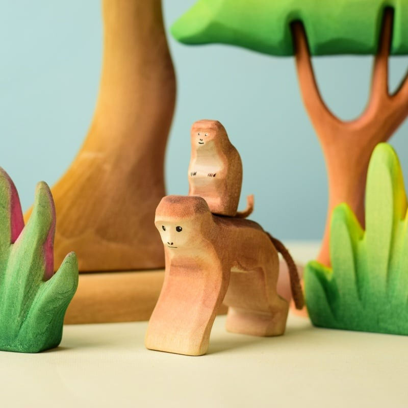 Thumbnail: Bumbu Toys Wooden Monkey Figurines Set in a nature play scene on a wooden surface