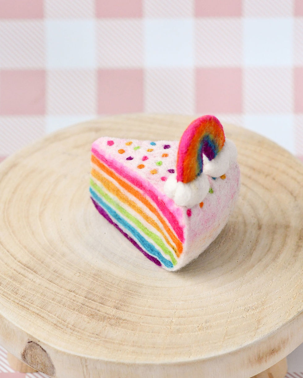 Thumbnail: Tara Treasures Felt Rainbow Cake Slice on a rustic wooden stand