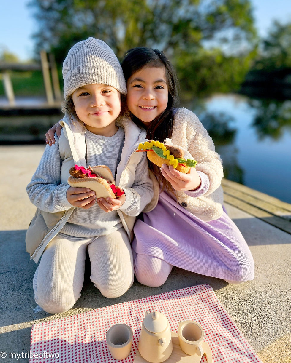 Two children are holding Tara Treasures Felt Play Food