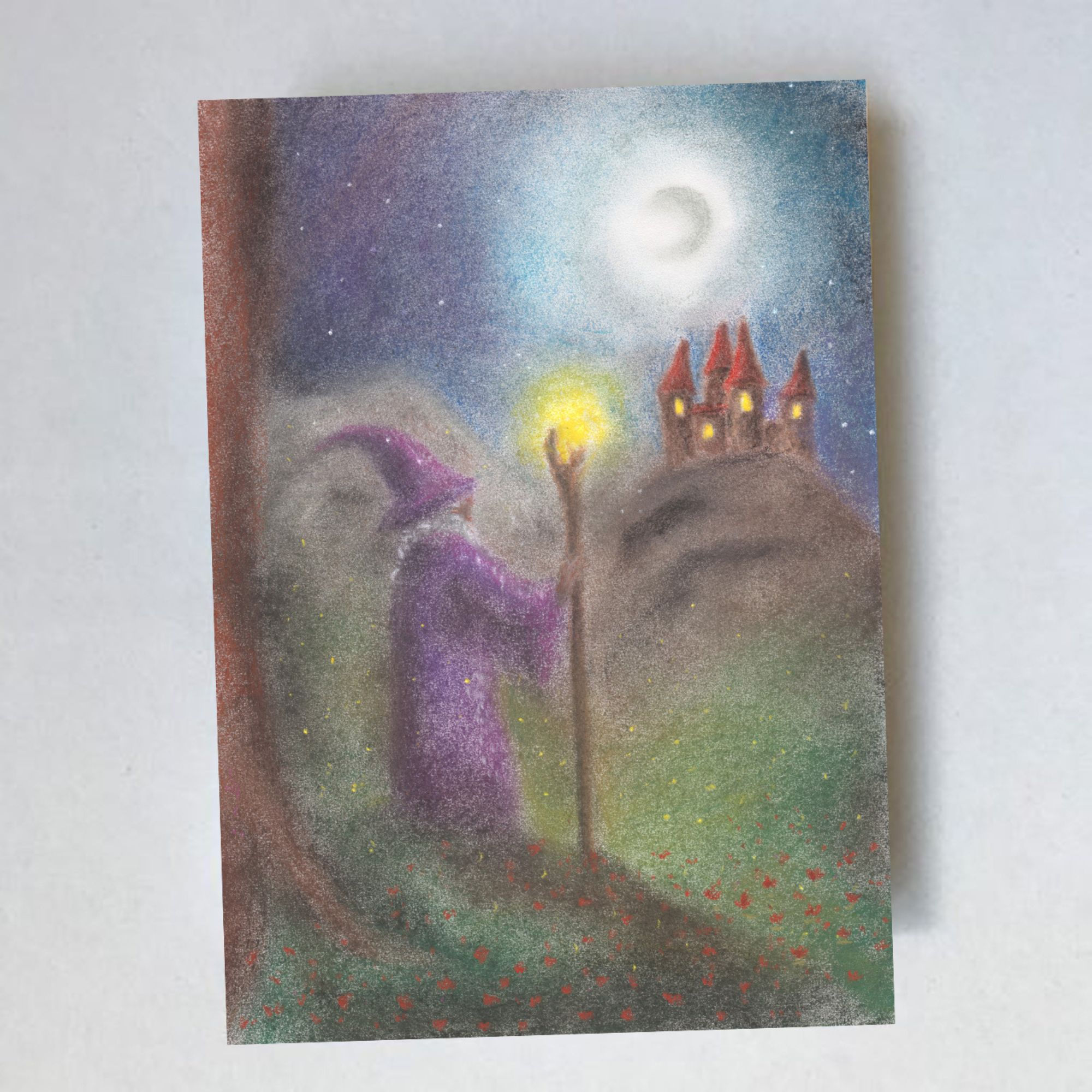An A6 postcard by Lot Bouwes, featuring a hand-illustrated pastel wizard with a glowing staff and a moonlit castle.