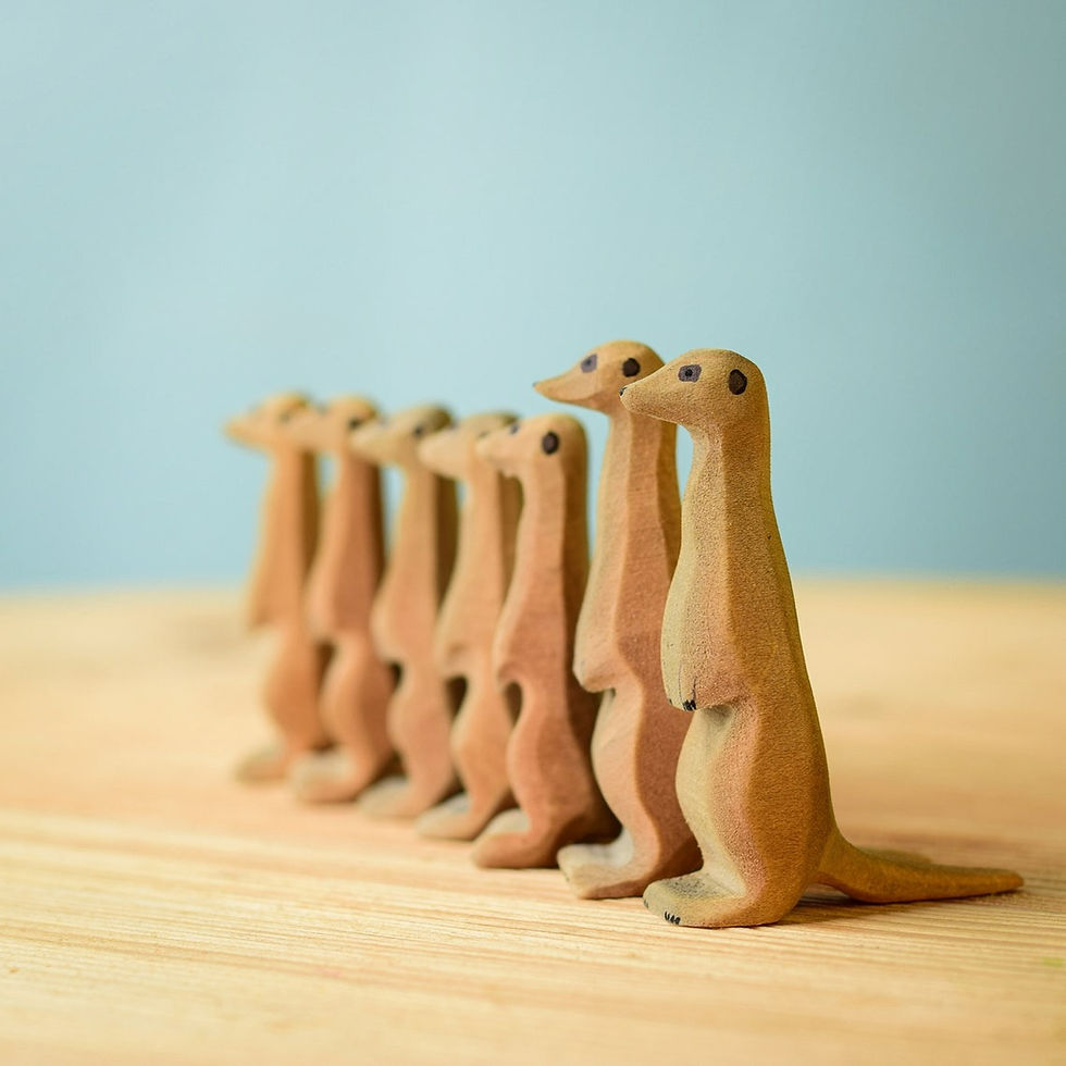 Handcrafted wooden meerkat figurines on a wooden surface by Bumbu Toys