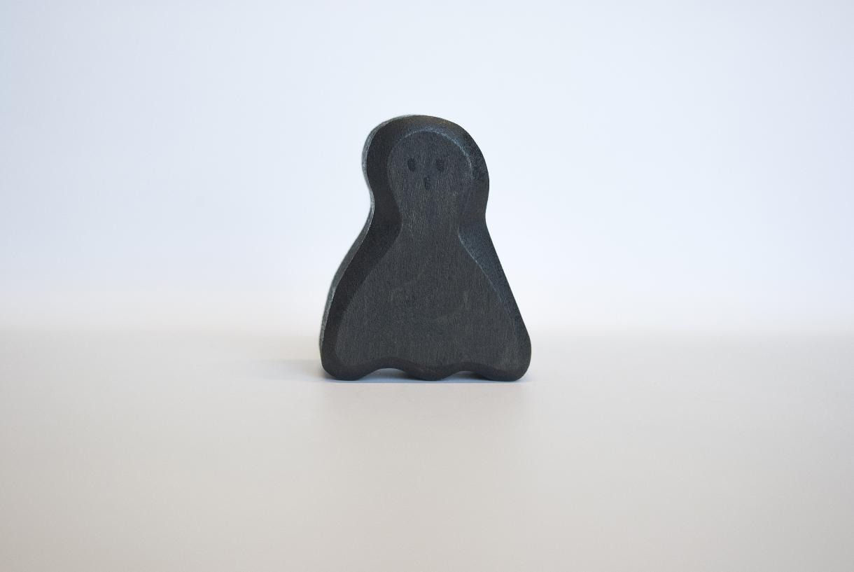 wooden black ghost figurine toy by Juharka, carved from maple wood with a dark finish and small, subtle hand-painted features