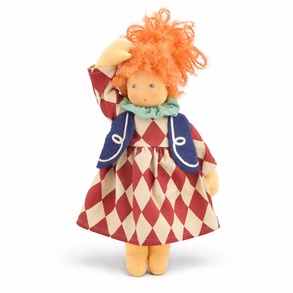 Front view of Nanchen Natur Tilda dress-up doll with orange mohair hair, a harlequin dress, and a blue vest.
