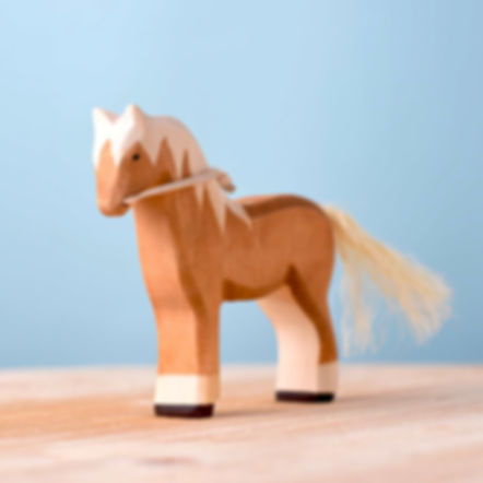 Bumbu Toys Handcrafted Wooden Brown Horse Figurine on a wooden surface