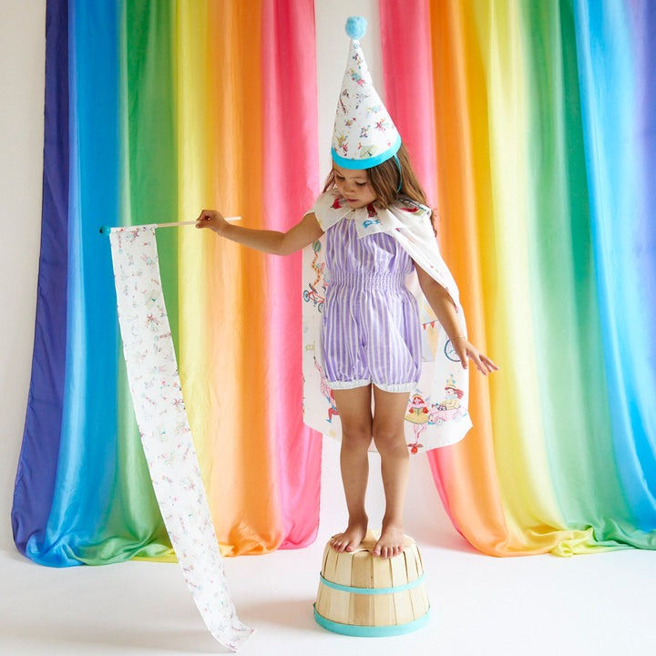 Thumbnail: A girl wearing the Sarah's Silks Circus Hat for Dress-up Illustrated by Phoebe Wahl