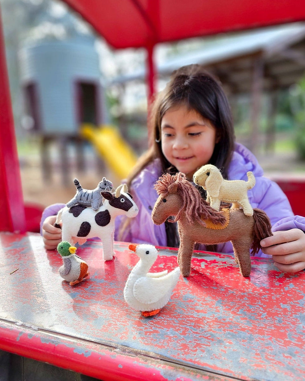 Thumbnail: A little girl playing with Felt Farm animals and Tara Treasures Felt Goose Farm Animal Toy