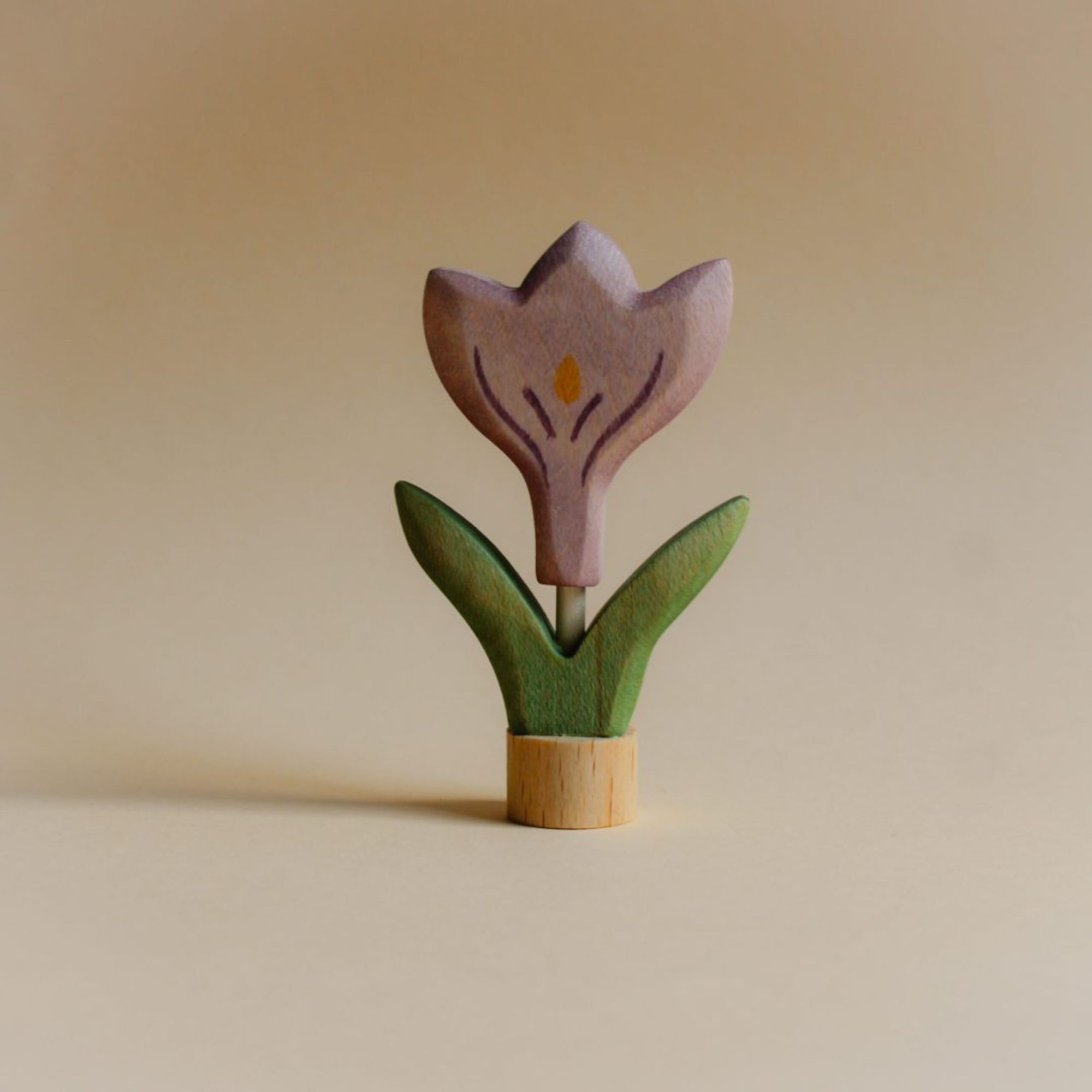 Hand-painted wooden crocus flower ornament by Juharka, featuring purple petals and green leaves on a 17mm maple wood base.
