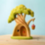 Thumbnail: The rear view of the wooden treehouse showing the hollow interior and carved window.