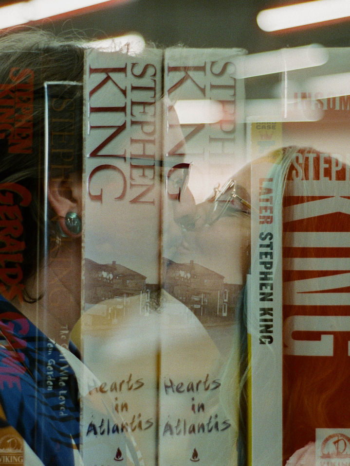 Creative double exposure engagement portrait of couple reflected in bookstore window at Half Price Books Austin