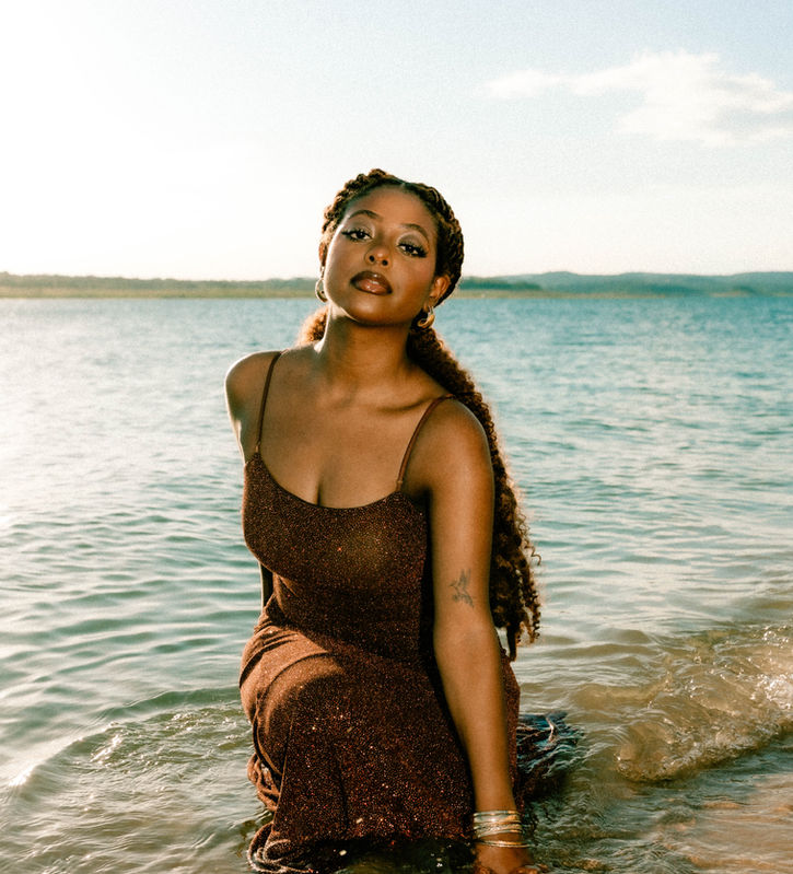Woman in golden dress standing in lake water during portrait session at Bob Wentz Park Austin