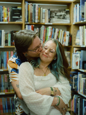 Romantic couple embracing among bookshelves during Half Price Books engagement session in Austin Texas