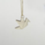 Pingente em porcelana com formato de um tsuru, minimalista, inspirado em origami, a dobradura japonesa. Com corrente em ouro amarelo.