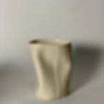 Vaso em porcelana branca, feito à mão, com curvas e "amassados" nas laterais. Textura listrada em toda a extensão. Visto de frente com fundo cinza.