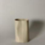 Vaso em porcelana branca, feito à mão, com curvas e "amassados" nas laterais. Textura listrada em toda a extensão. Visto de frente com fundo cinza.