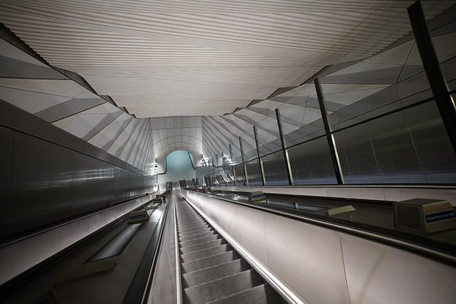 A folded concrete ceiling is the main architectural flourish by architecture firm WilkinsonEyre at Liverpool Street's Elizabeth Line station, squeezed into a tight space below the heart of London's financial district between sewers and existing rail tunnels.  The ceiling was designed to maximise the perception of height and create a feeling of scale and movement in the constrained spaces, with mica crystals mixed into the pre-cast white concrete to glow in the indirect lighting.