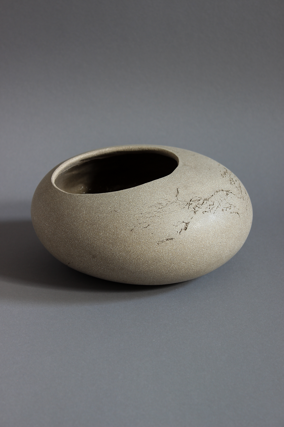 Thumbnail: Empty grey ceramic flowerpot photographed from an angled view against a grey studio background.