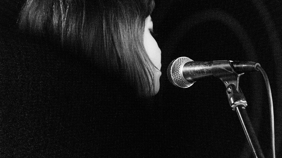 Singer performing into a microphone in a dark room