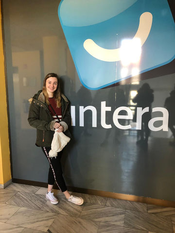 Woman standing near Intera logo