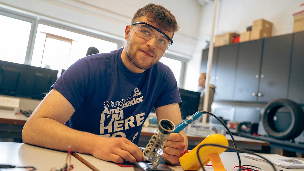 Student soldering electronics in a classroom