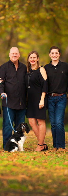 family and their cocker spaniel standing beneath the arching branches of a giant oak tree in Brazos Park East.