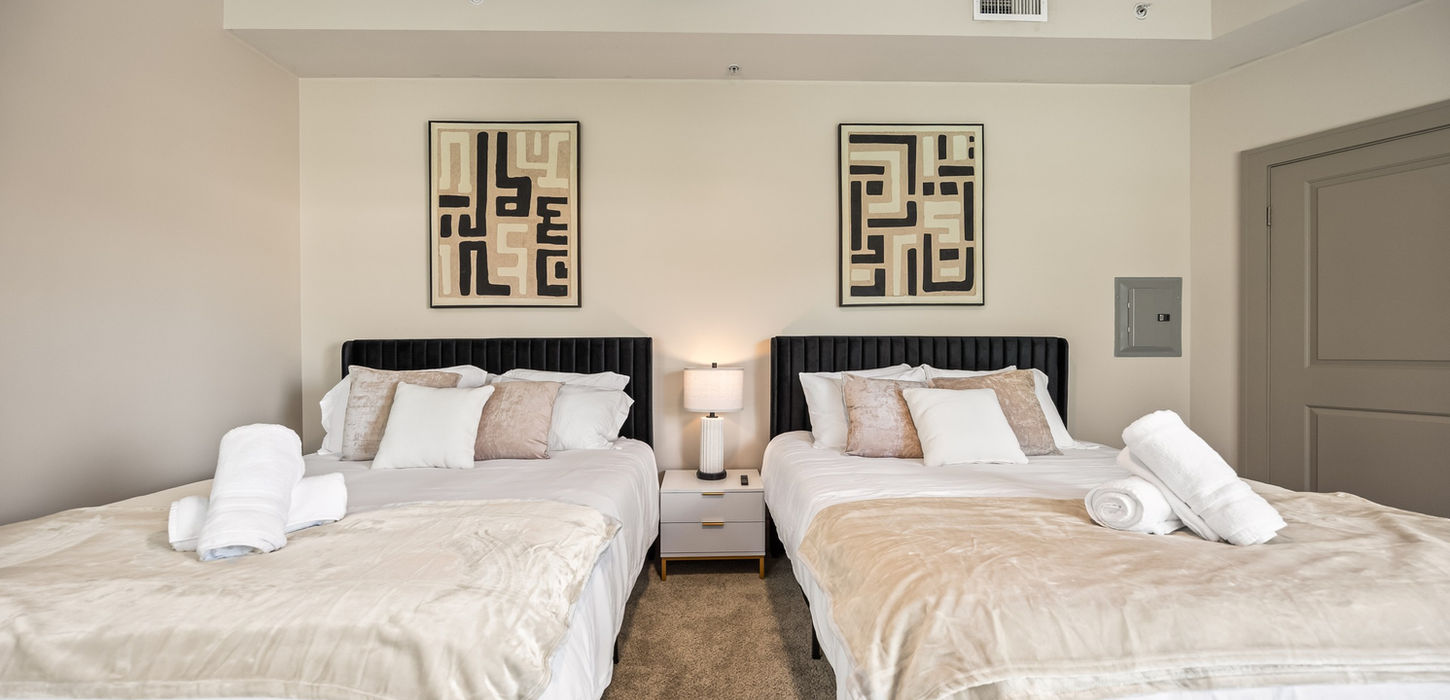 Two beds with white linens, lamp, art, interior design, furnished rentals