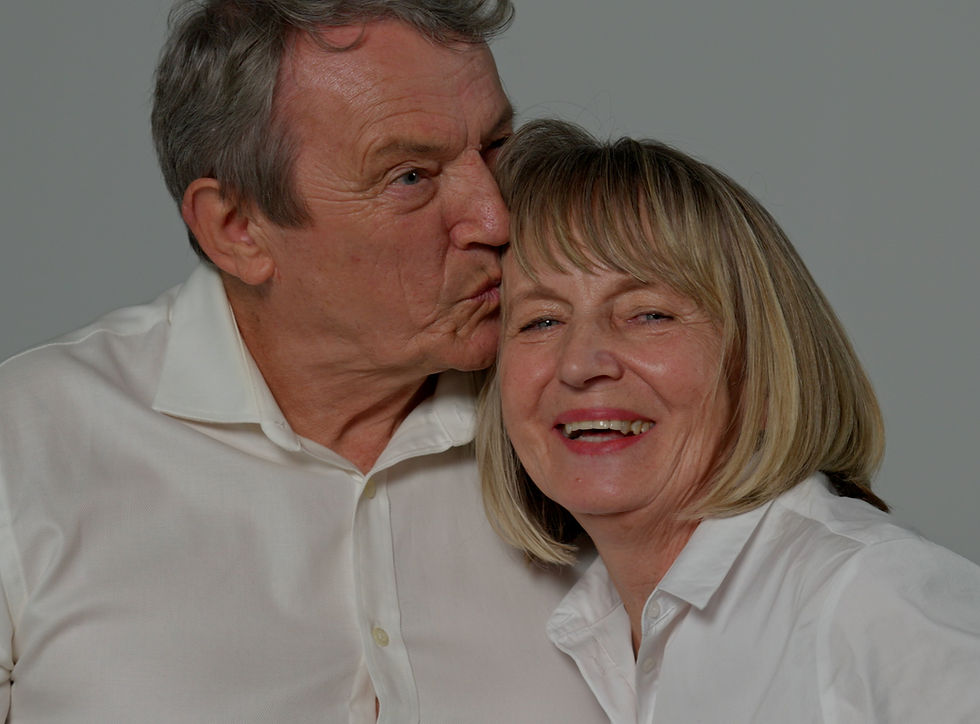 Senior man kissing smiling woman's forehead