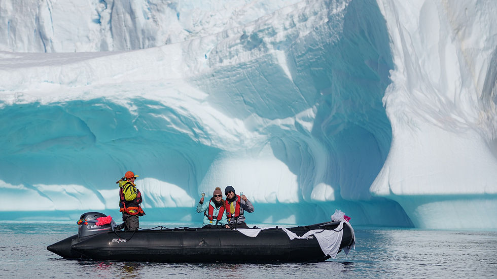 Turistas navegan en bote frente a un gran iceberg, EL ÁRTICO, en el mar helado.